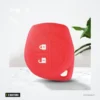 Housse de clé en silicone 2 boutons pour Suzuki Swift, SX4, Vitara, Jimny - housse rouge posée sur un support avec une plante